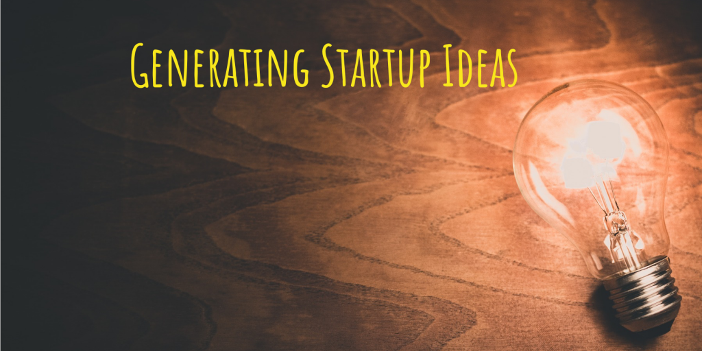 lit up lightbulb on a wooden desk, with the words, "generating startup ideas" written over top